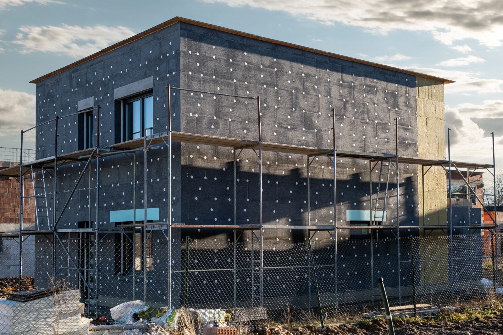 ModernThermalInsulationMaterialsBuildingNewHouseInProcessInsulation - Χόρμπας και Γιαννακόπουλος - Οικοδομικές Εργασίες - Πάτρα Θερμοπρόσοψη: Η Σημαντικότητα και τα Οφέλη για το Σπίτι σας στην Πάτρα